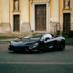 Lamborghini Temerario grigia della flotta GC Auto, vista frontale con fari esagonali a LED accesi in un borgo storico italiano